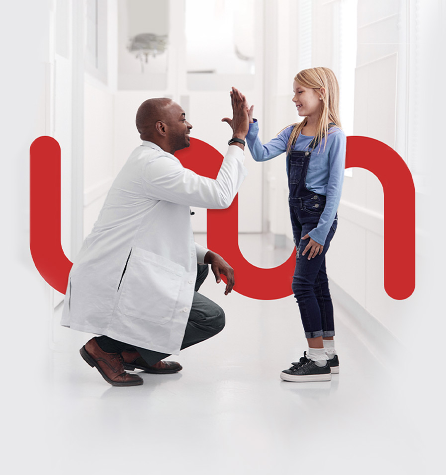 Médico agachado dando mão para criança em pé