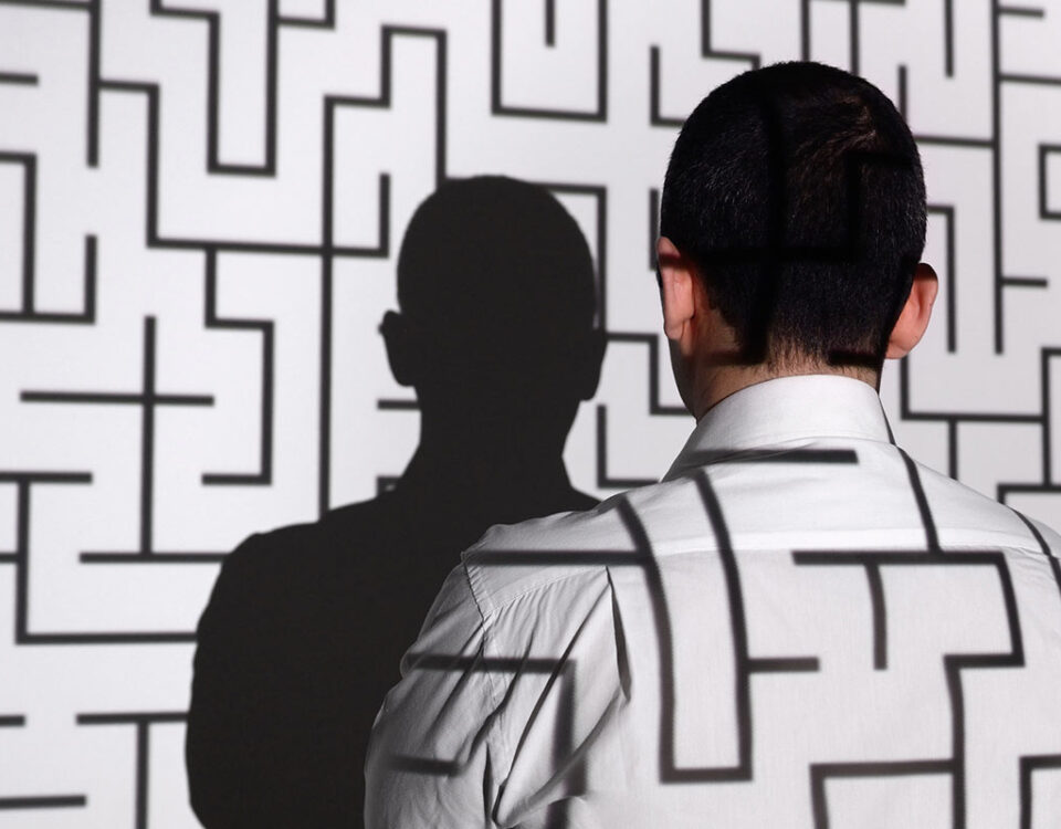 Homem virado para uma parede com um labirinto como se estivesse perdido em referência a erros de marketing digital