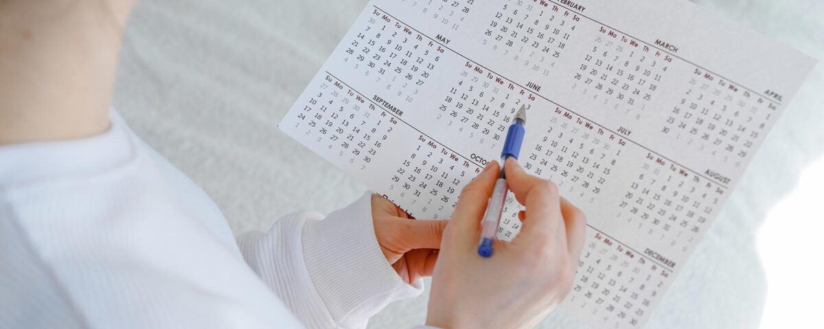 Mulher anotando com caneta em calendário