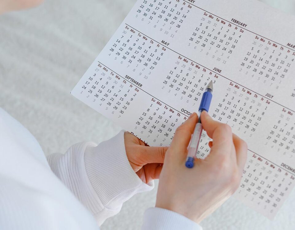 Mulher anotando com caneta em calendário