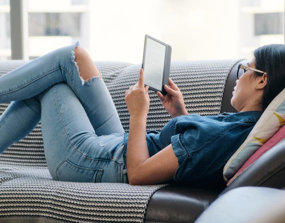 Mulher deitada lendo ebook