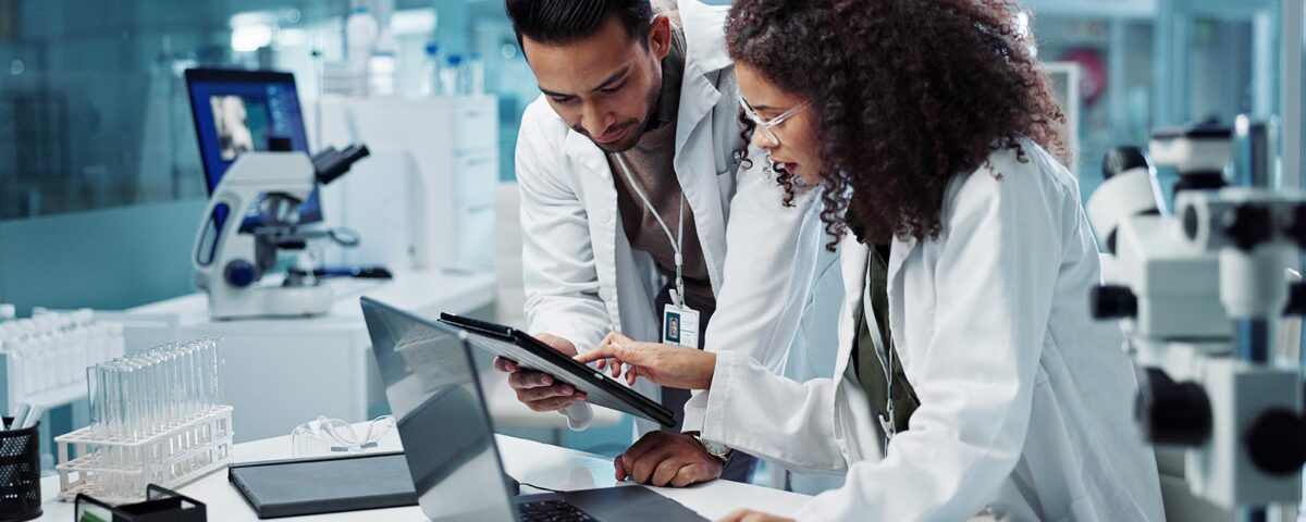 Pesquisadores em laboratório analisando dados em tablet