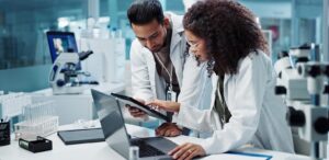 Pesquisadores em laboratório analisando dados em tablet