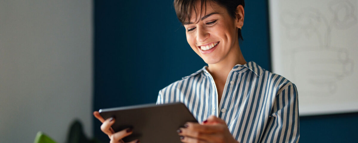 Mulher sorrindo ao ler um com conteúdo em saúde