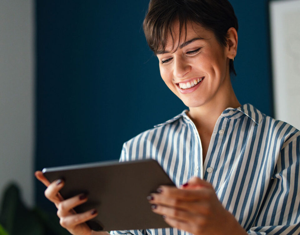 Mulher sorrindo ao ler um com conteúdo em saúde