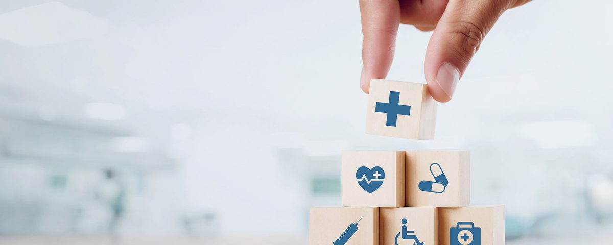 Feche a mão do homem organizando bloco de madeira com ícone médico de saúde n