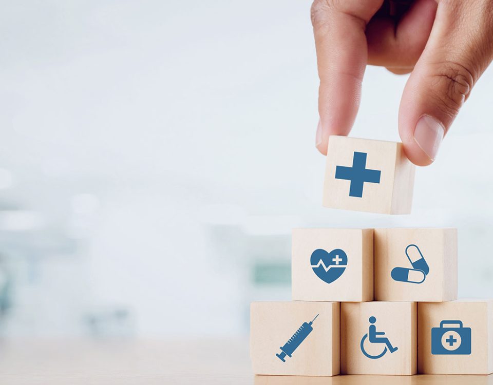 Feche a mão do homem organizando bloco de madeira com ícone médico de saúde n